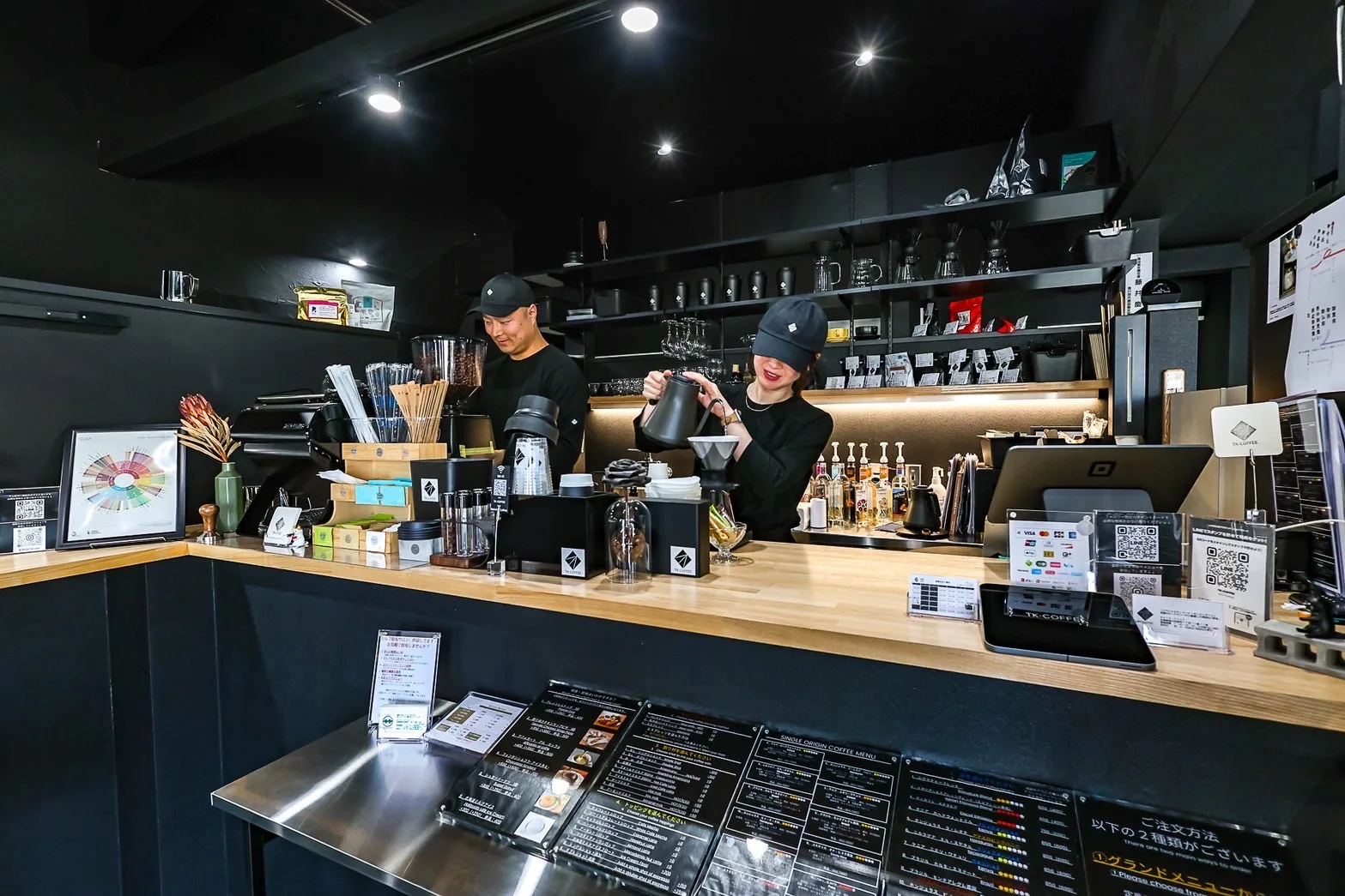 黒い店内のカウンターで働くTK-COFFEEの店主夫婦